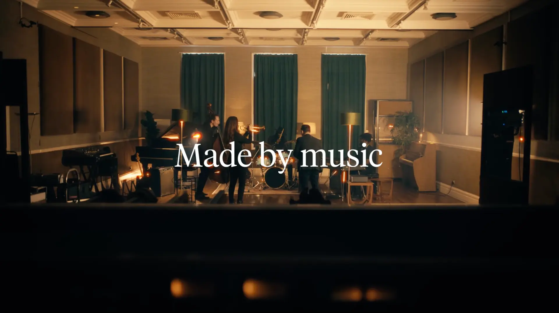Cambridge Audio campaign still reading Made by music, with musicians on a stage